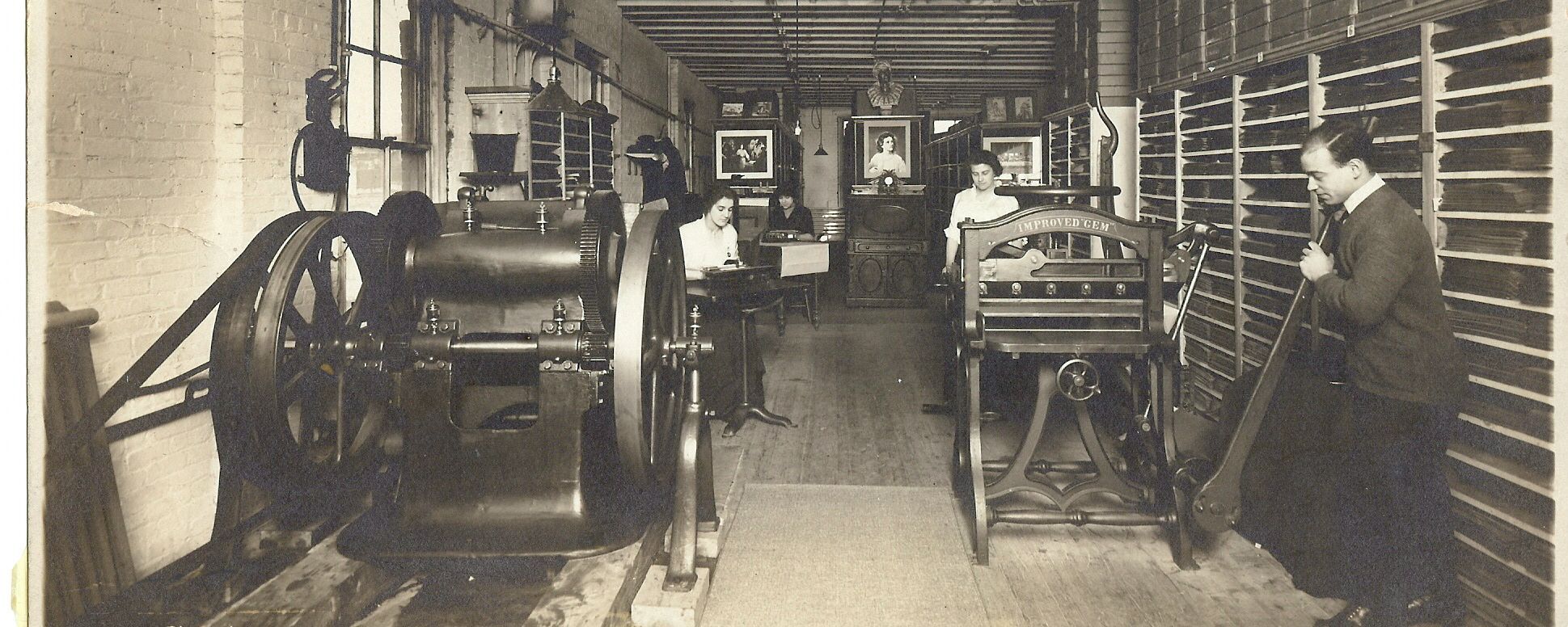 Print shop shown with big machines and people working with transcribers