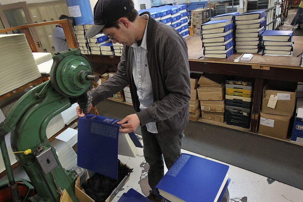 A man diligently binding one of our braille Bibles