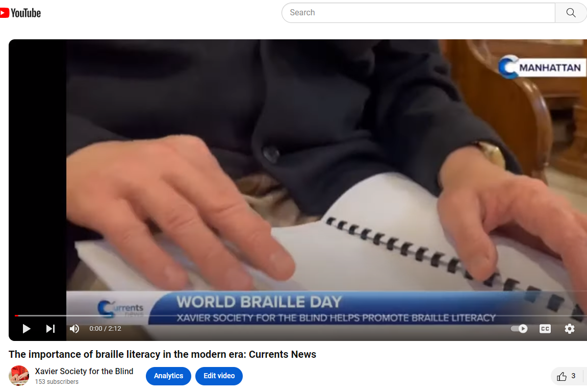 Skylar's fingers reading braille in a pew at St. Francis Xavier church at our 2023 St. Lucy Mass